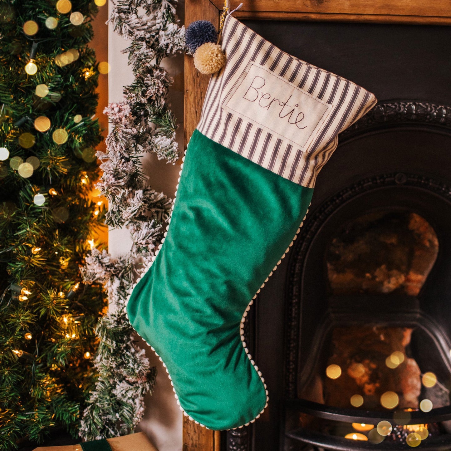 Personalised velvet Christmas stocking with mini pom pom trim and embroidered tag