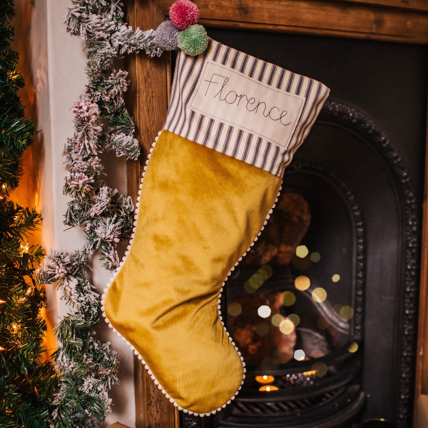 Personalised velvet Christmas stocking with mini pom pom trim and embroidered tag