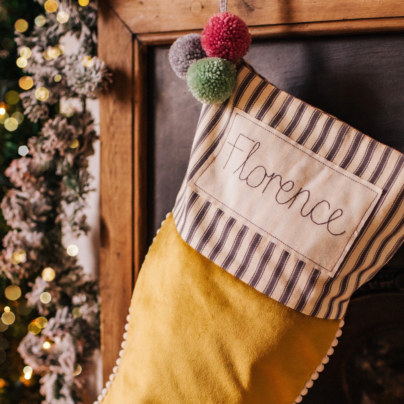 Personalised velvet Christmas stocking with mini pom pom trim and embroidered tag
