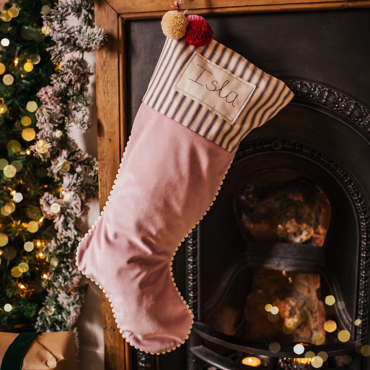 Personalised velvet Christmas stocking with mini pom pom trim and embroidered tag