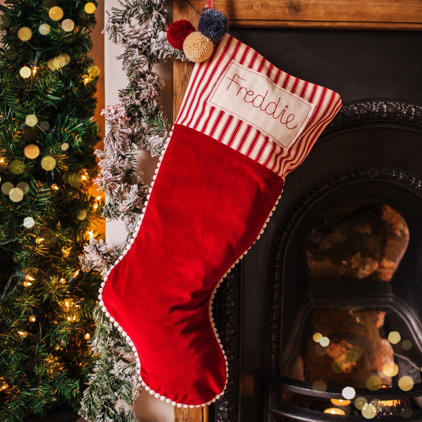 Personalised velvet Christmas stocking with mini pom pom trim and embroidered tag