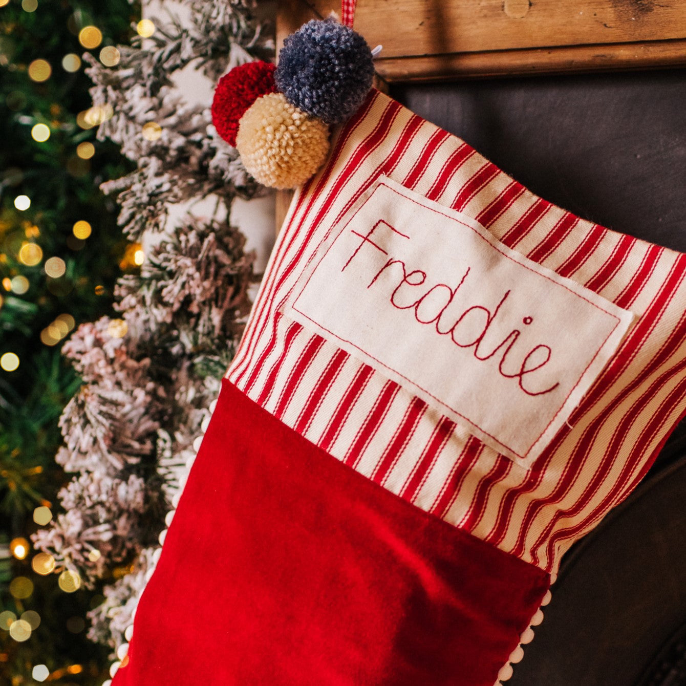 Personalised velvet Christmas stocking with mini pom pom trim and embroidered tag
