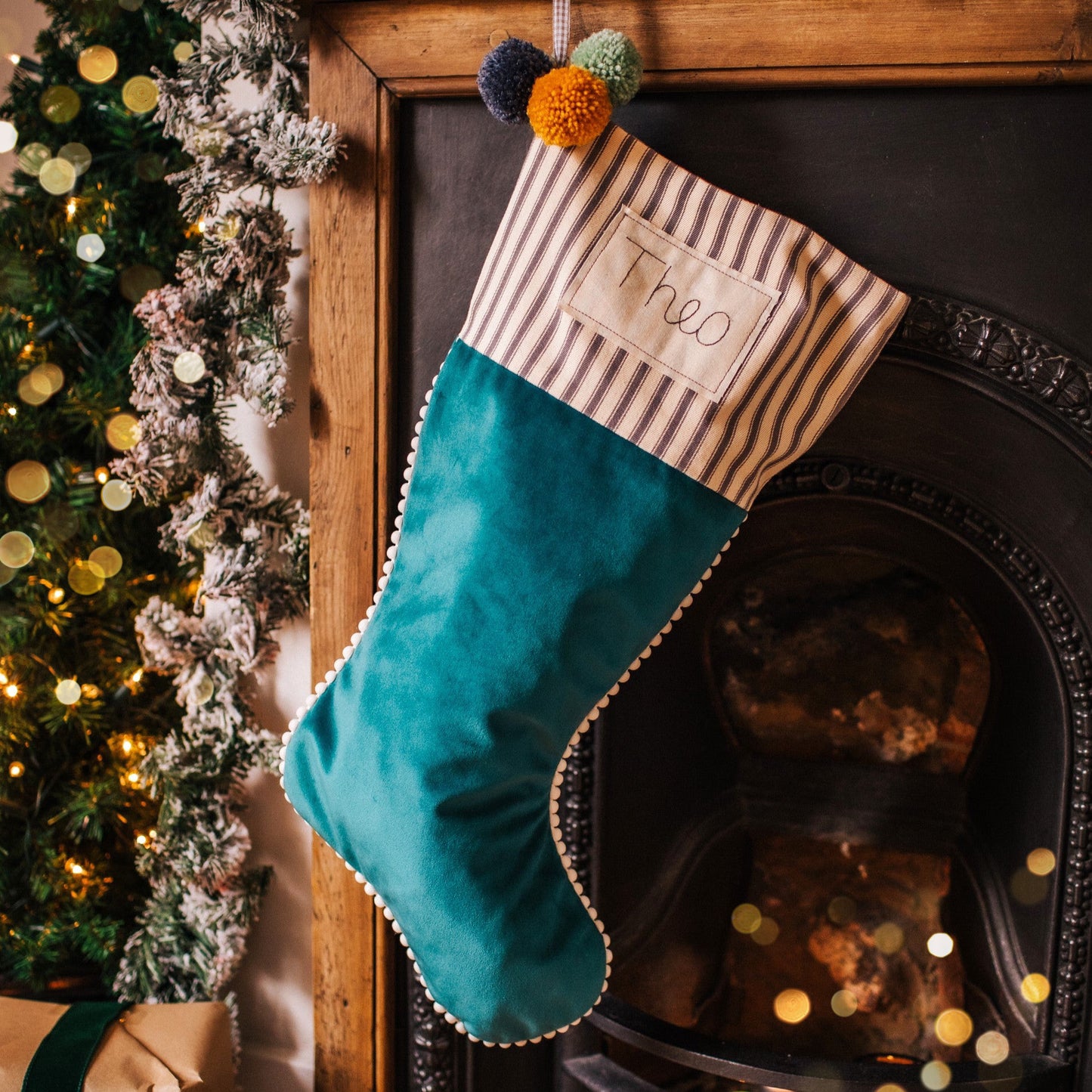 Personalised velvet Christmas stocking with mini pom pom trim and embroidered tag
