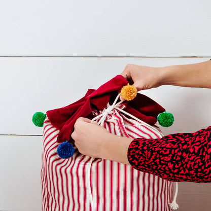 Personalised Christmas sack with pom pom details and embroidered personalised tag.