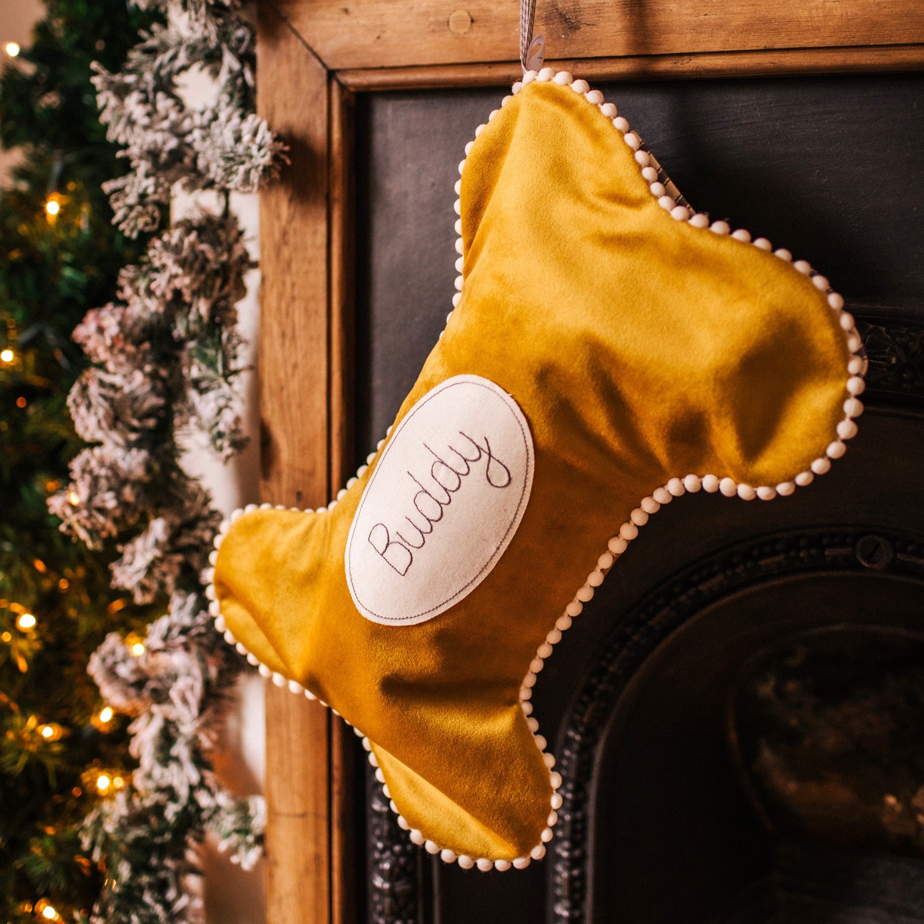 Velvet dog bone shaped personalised stocking. Lined in cotton with a pom pom trim.