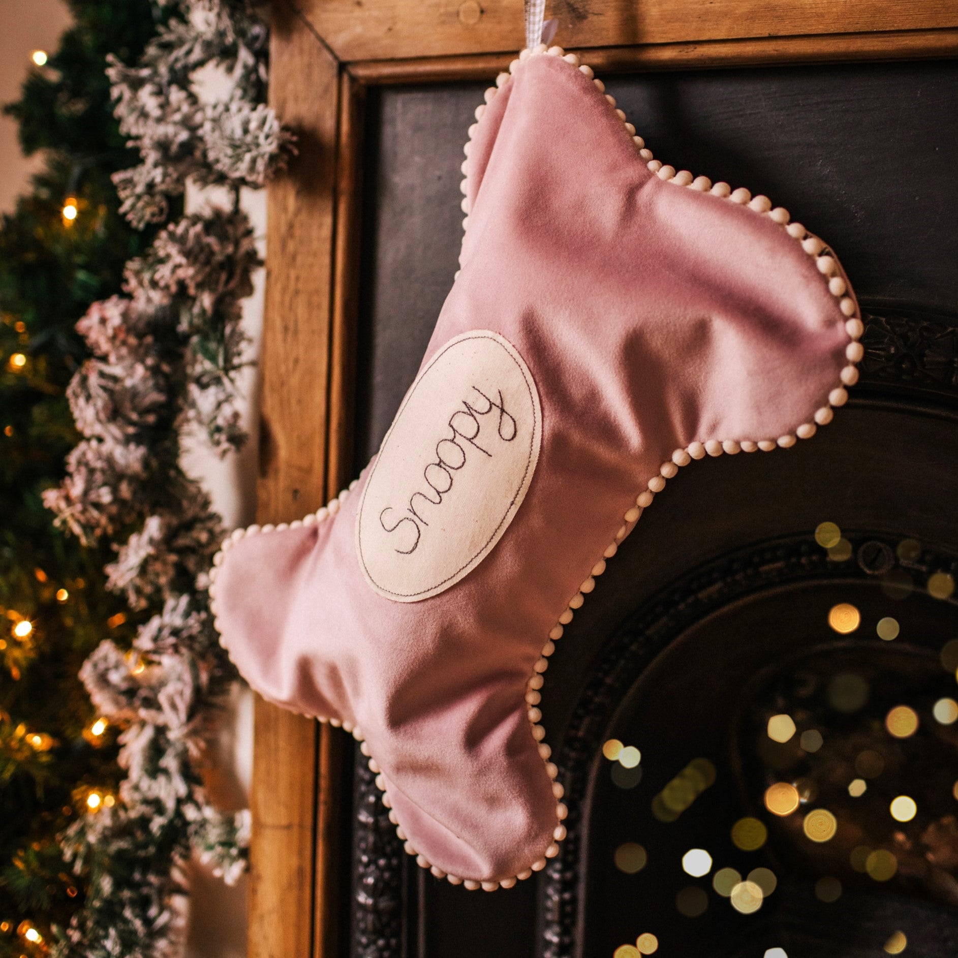 Velvet dog bone shaped personalised stocking. Lined in cotton with a pom pom trim.