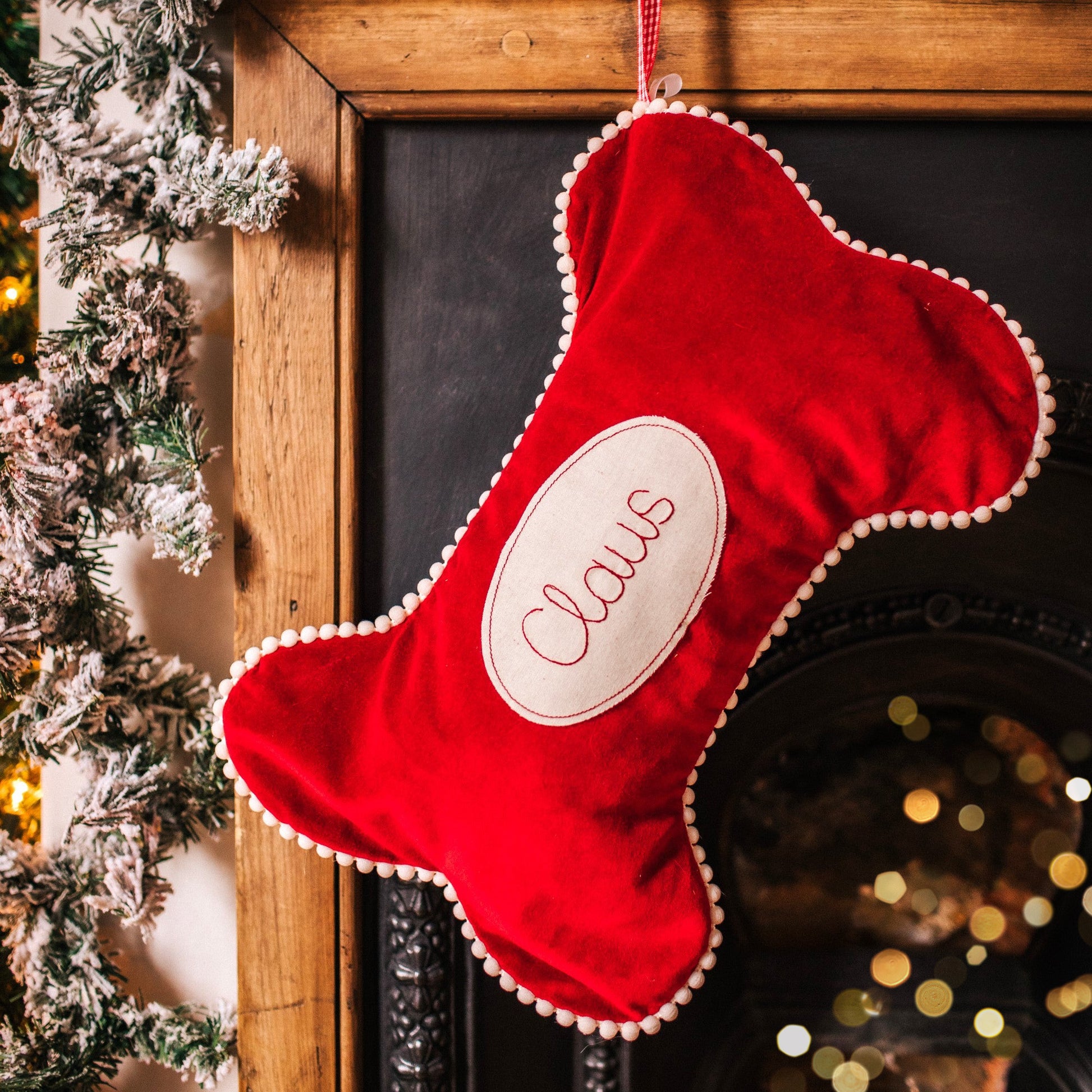 Velvet dog bone shaped personalised stocking. Lined in cotton with a pom pom trim.