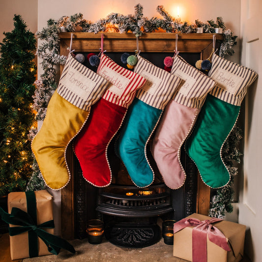 Personalised velvet Christmas stockings with mini pom pom trim and embroidered tag