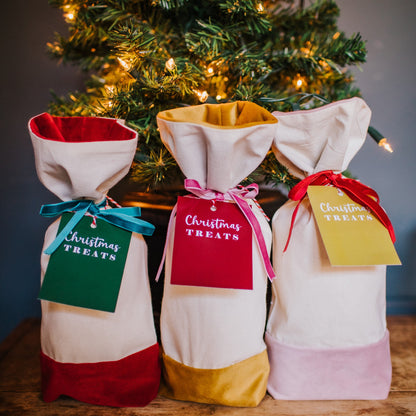 A reusable cotton and velvet gift bag with gift tag